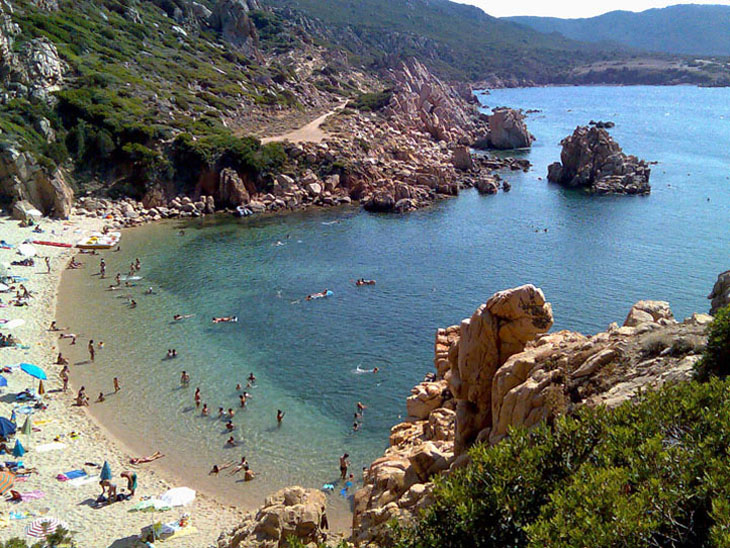 I turisti si tuffano nel mare verde smeraldo di Spiaggia Li Cossi a Costa Paradiso